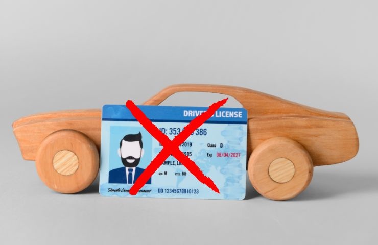 una macchina di legno e la patente con una x